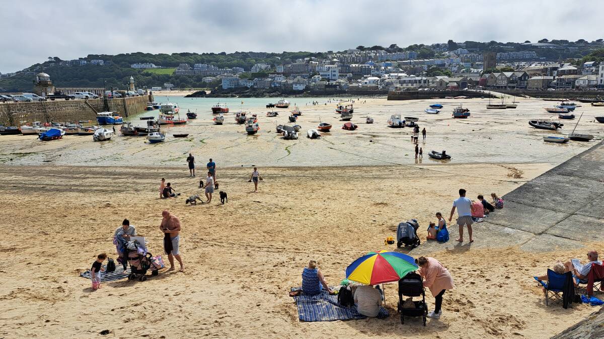The tide is six metres high in St Ives, Cornwall, and when it goes out, the beach-goers descend. Picture: Sarah Falson