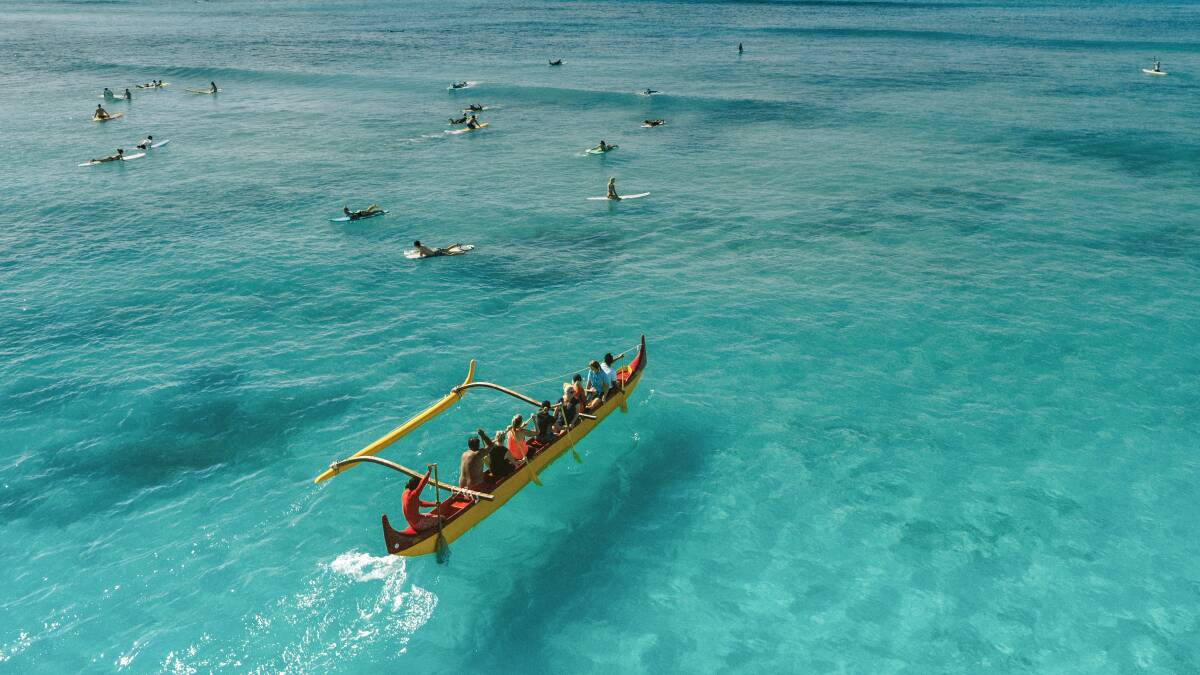 Outrigger canoe paddling Waikiki Beach.